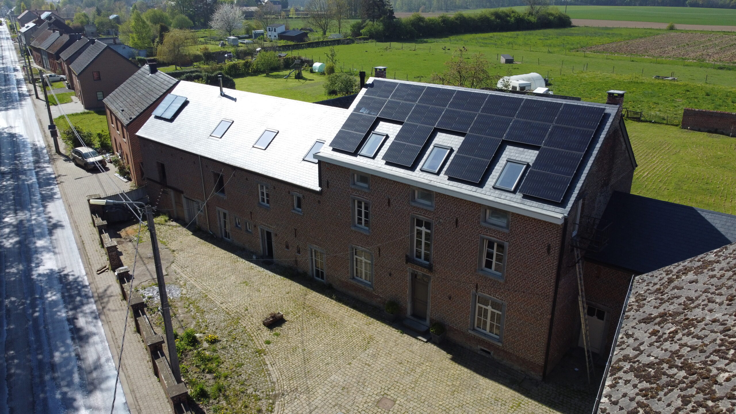 Vue large sur une maison 3 façade avec panneaux solaires installés sur toit en pente
